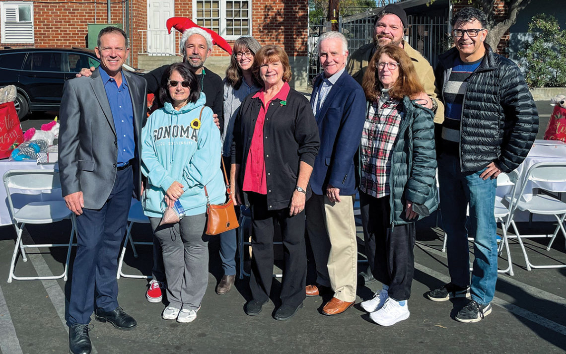 A group of volunteers stand together outside. 