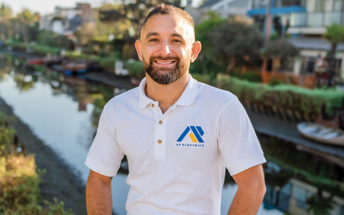 The owner of AP Electrics stands on the Venice Canals